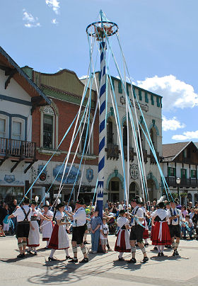 View of Bavarian Festival dancers in colorful costumes dancing in the street