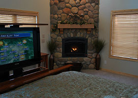 Interior of the room showing TV at the foot of the bed and the fireplace.