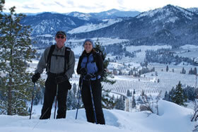 Exterior view of Innkeepers snowshoeing on a mountain top surrounded by white snow.